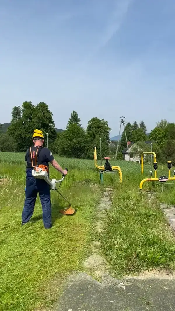 Pracownik HEFEST kosi trawę w parku biznesowym